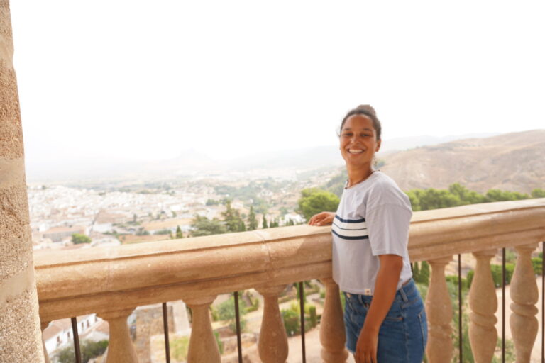 Shannon, solo female travel blogger, exploring a scenic fortress in Spain